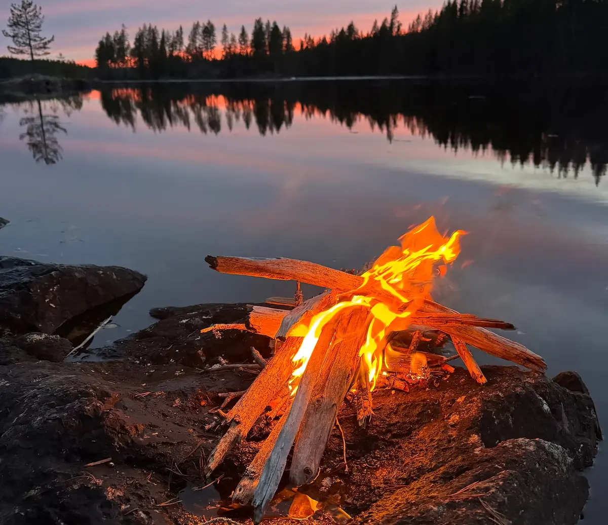 Campfire by a lake at dusk